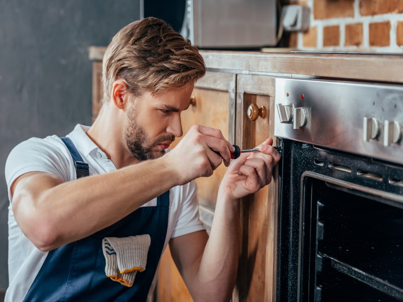técnico reparando Horno Siemens.